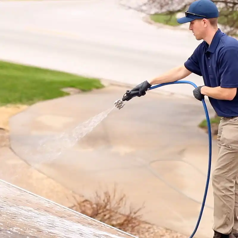 pressure cleaning professional washing roof in black gloves